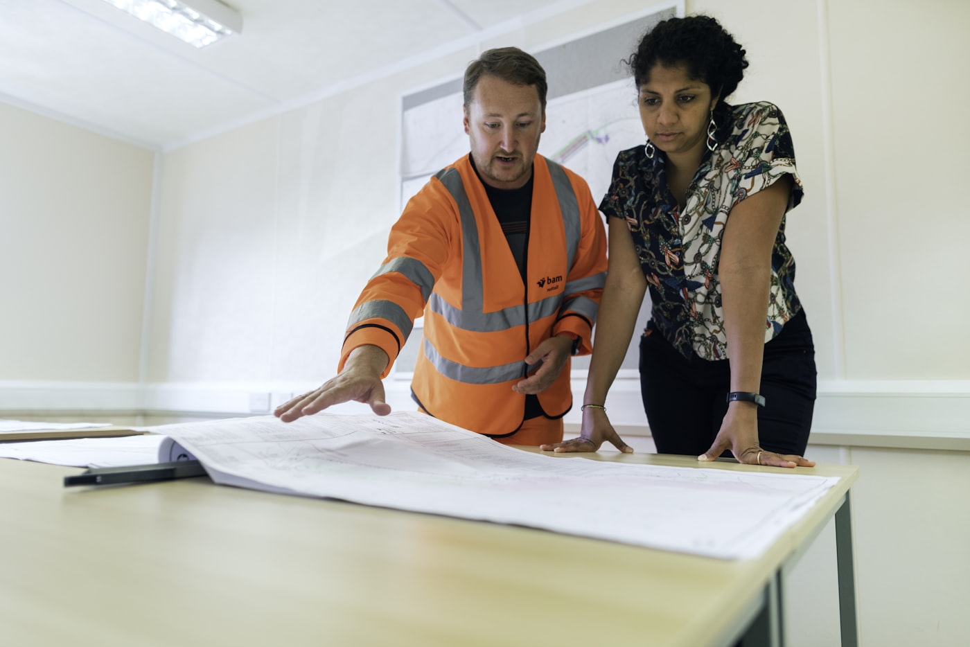 A consultant and client reviewing process documentation together on-site.